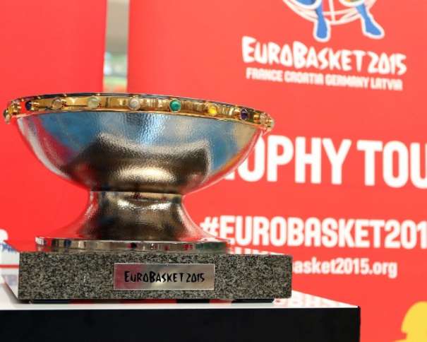 En esta foto podemos ver la Copa de Campeones del EuroBasket, en el Tour que está realizando, en el Trophy Tour, delante de uno de los photo-calls diseñados para ese momento