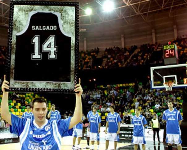 En esta foto podemos ver cómo Javi Salgado levanta el recuerdo de la camiseta con el número 14 que se retiraba en su Homenaje, recuerdo recibido en forma de camiseta enmarcada dentro de un cuadro, entre 2 cristales