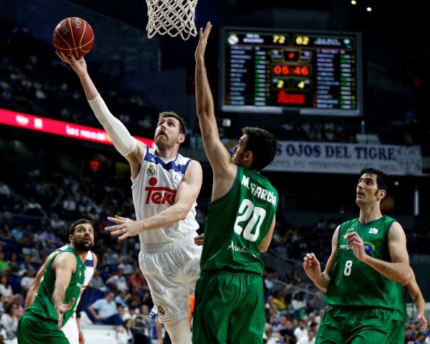 En esta foto, facilitada por la Liga ACB, podemos ver a Andrés Nocioni a punto de Anotar con su mano derecha, debajo de la canasta, superando a los Defensores del Sevilla