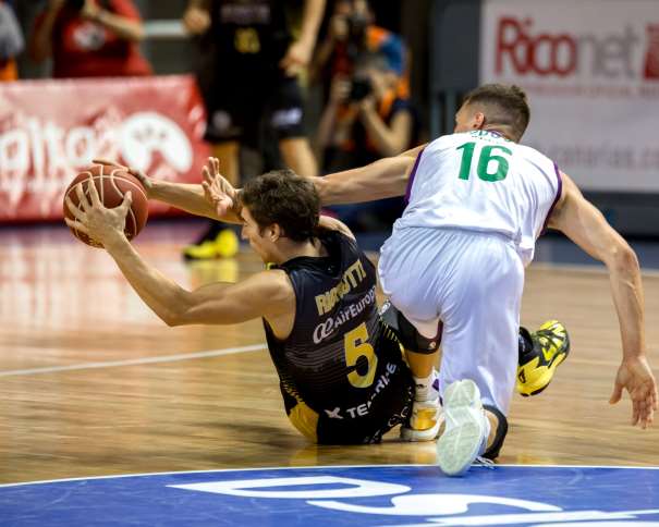 En esta foto, facilitada por la Liga ACB de Baloncesto, podemos ver al jugador del Tenerife, Nico Richotti, consiguiendo proteger el balón, evitando, desde el suelo, que el Málaga pueda recuperarlo